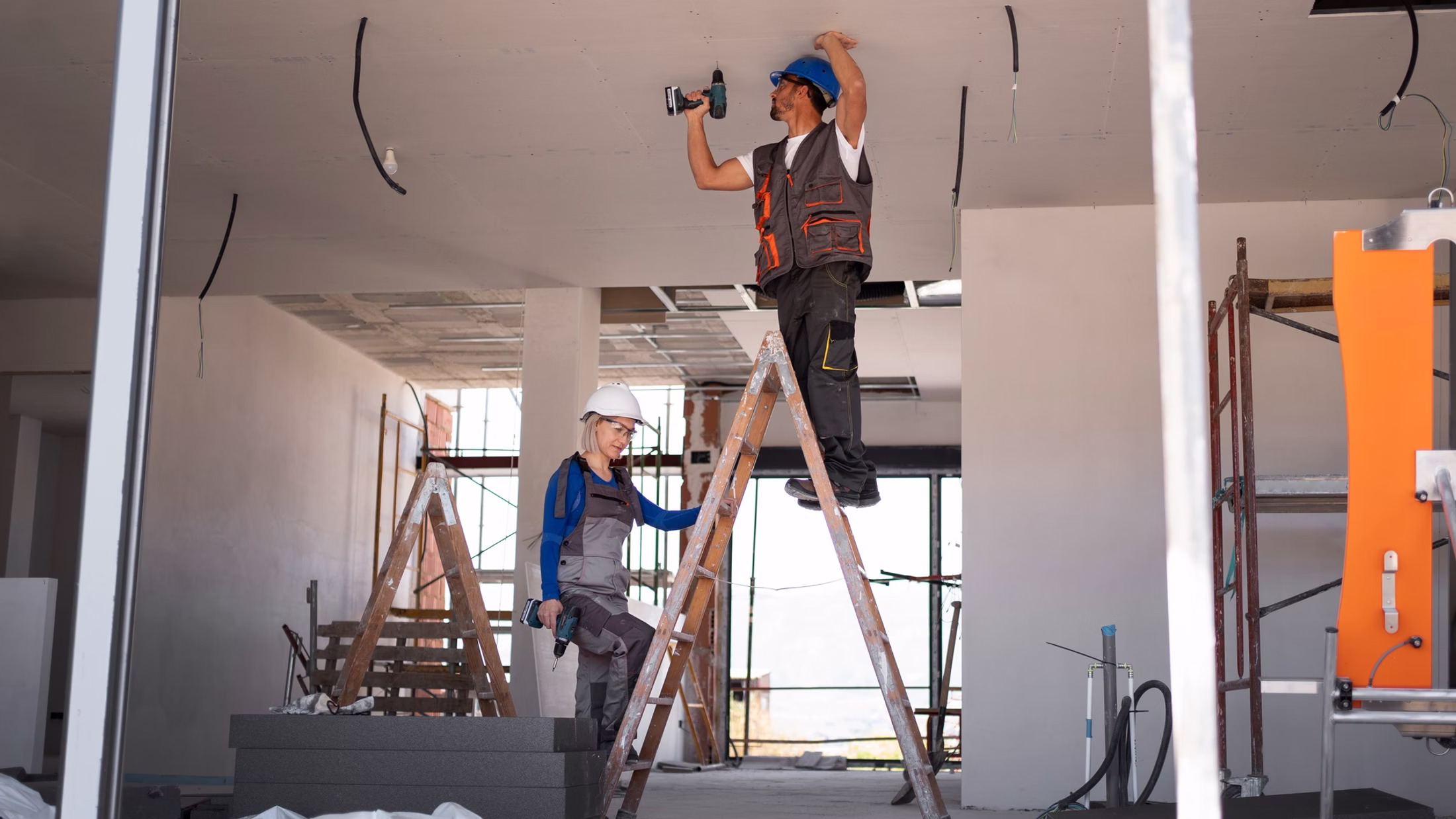Handwerker montieren eine Trockenbaudecke mit Gipsplatten